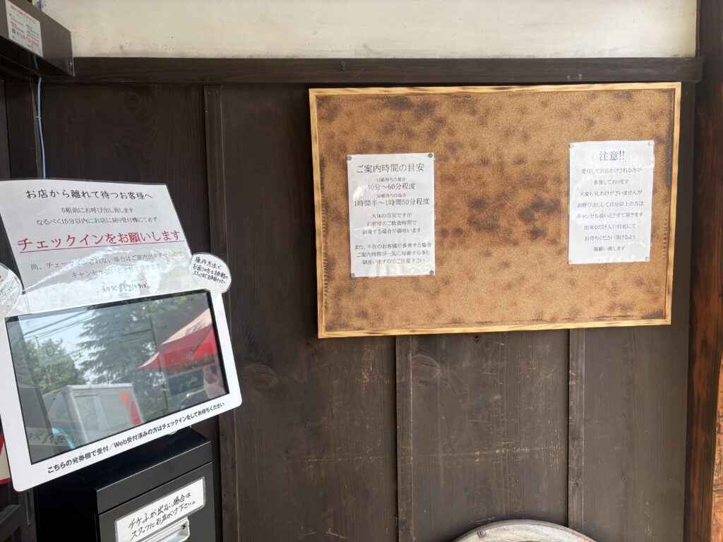 ご案内までの待ち時間の目安を伝える掲示板とチェックイン用タブレット